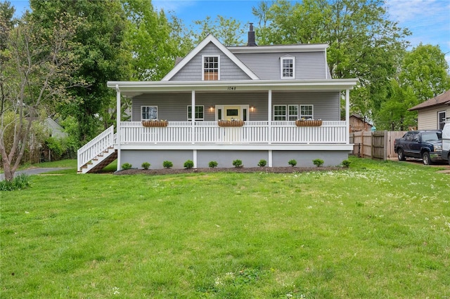 view of front of property with a front yard, covered porch, fence, and a chimney