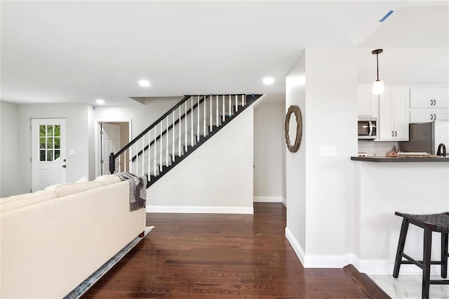 interior space with stairs, baseboards, wood finished floors, and recessed lighting