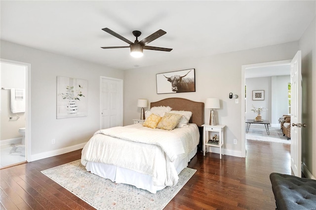 bedroom featuring dark wood-style floors, ensuite bathroom, a ceiling fan, and baseboards