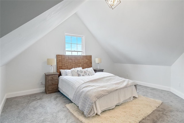 carpeted bedroom with lofted ceiling and baseboards