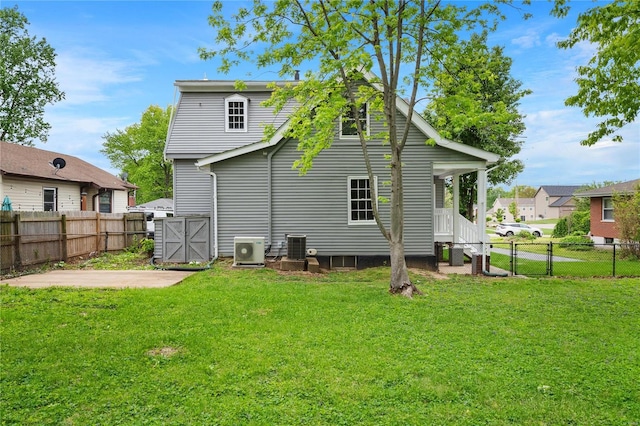 back of property with fence private yard, a gate, a yard, and ac unit