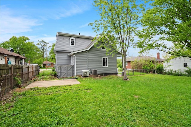 back of house featuring a yard, cooling unit, and fence