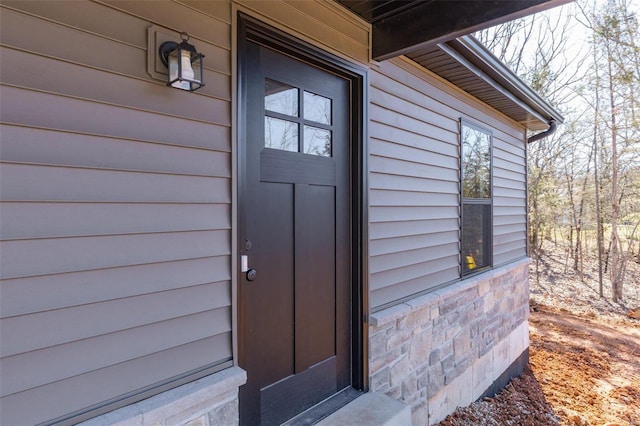 view of exterior entry featuring stone siding