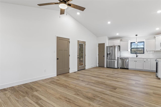 kitchen featuring light wood-style floors, appliances with stainless steel finishes, light countertops, and a sink