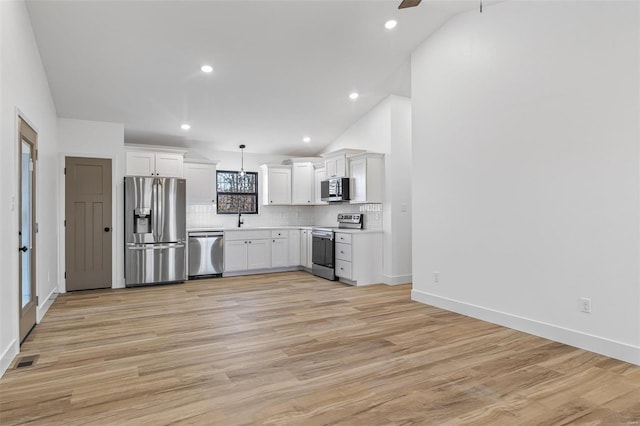 kitchen with visible vents, white cabinetry, light countertops, appliances with stainless steel finishes, and backsplash