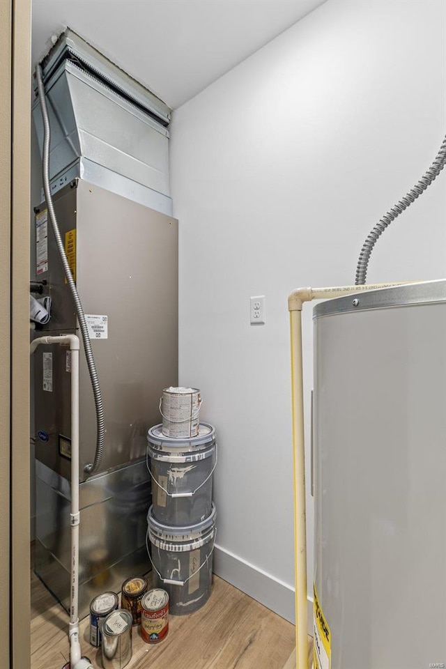 utility room featuring heating unit and water heater