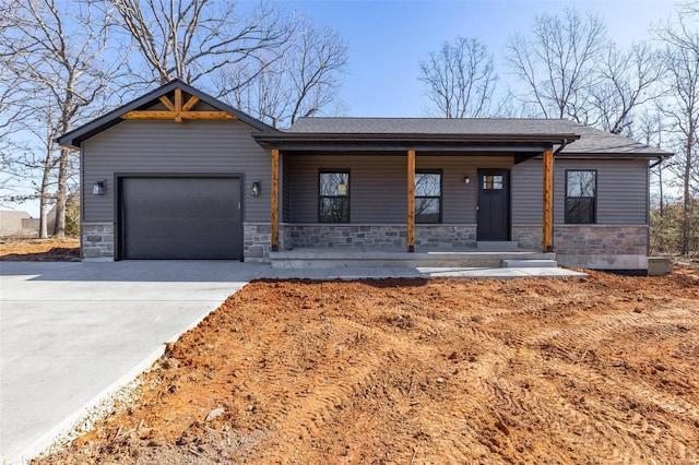 view of front of home featuring concrete driveway, stone siding, a porch, and an attached garage