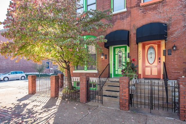 exterior space with brick siding, fence, and a gate