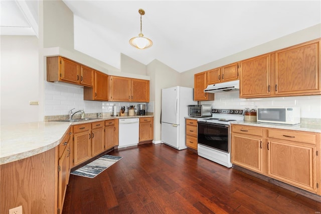 kitchen with under cabinet range hood, white appliances, dark wood-type flooring, a sink, and vaulted ceiling