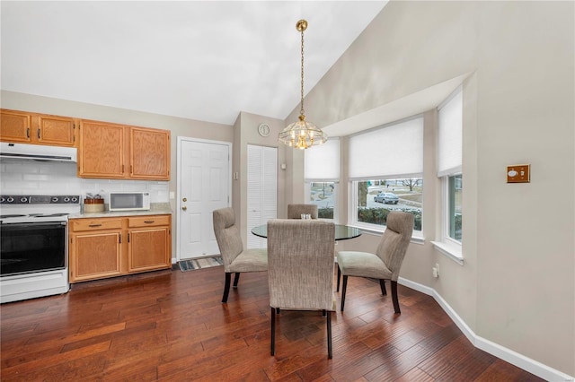 dining area with a chandelier, dark wood finished floors, high vaulted ceiling, and baseboards