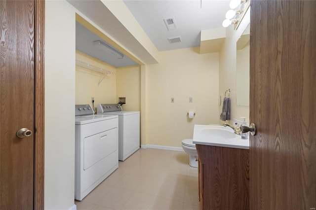 bathroom featuring toilet, separate washer and dryer, vanity, visible vents, and baseboards