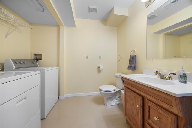 bathroom with visible vents, vanity, baseboards, and separate washer and dryer