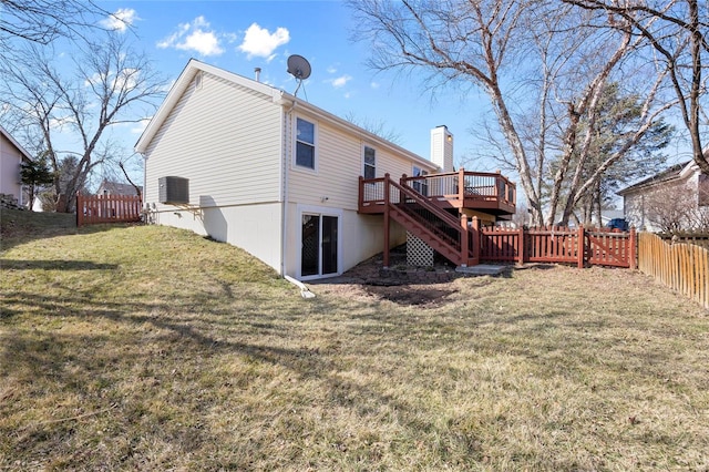 rear view of property with a fenced backyard, stairway, a lawn, a wooden deck, and a chimney