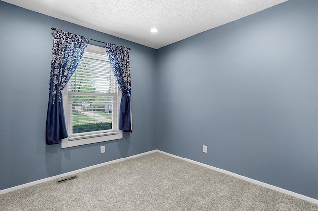 spare room featuring visible vents, baseboards, recessed lighting, a textured ceiling, and carpet flooring