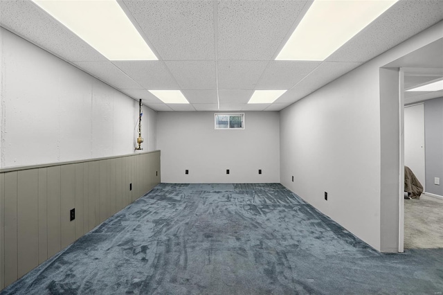basement featuring a drop ceiling and carpet