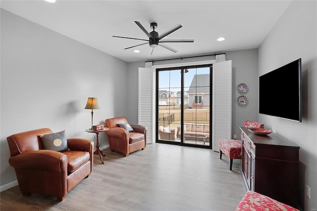 living area featuring light wood-style flooring, baseboards, and recessed lighting