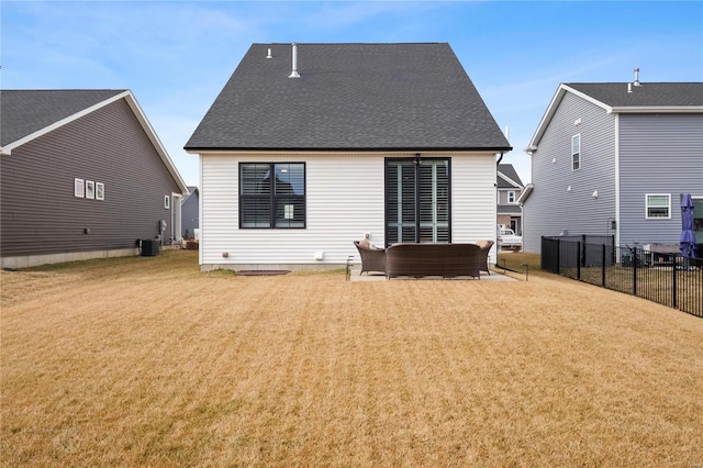 rear view of house featuring roof with shingles, central AC, a yard, and fence