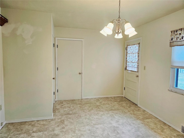 unfurnished dining area featuring visible vents, a notable chandelier, and baseboards