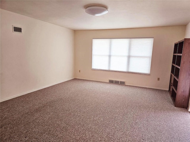 unfurnished room with baseboards, visible vents, and carpet flooring