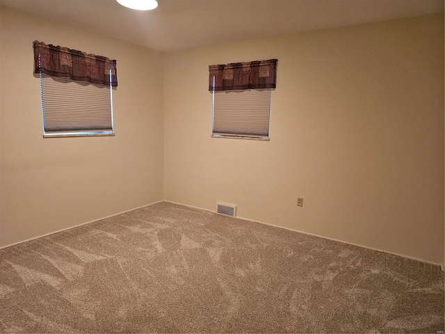 empty room featuring carpet floors and visible vents