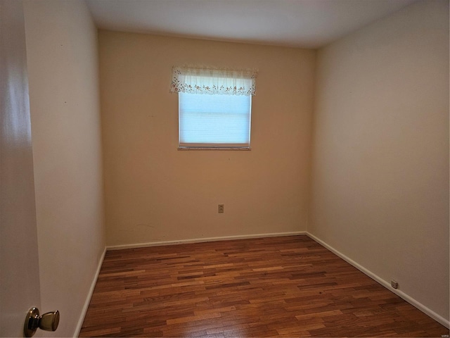 unfurnished room with dark wood-style flooring and baseboards