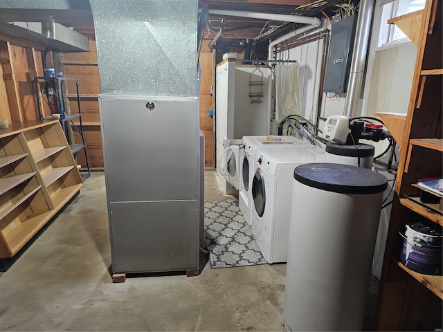 washroom with heating unit, laundry area, electric panel, and washing machine and clothes dryer