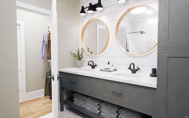 bathroom featuring double vanity, a sink, and wood finished floors