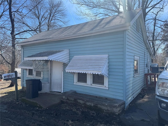 exterior space featuring roof with shingles