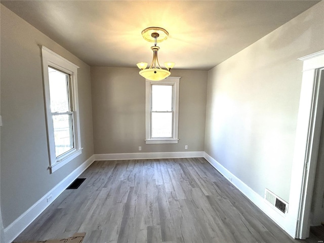 unfurnished dining area featuring a healthy amount of sunlight, visible vents, and baseboards