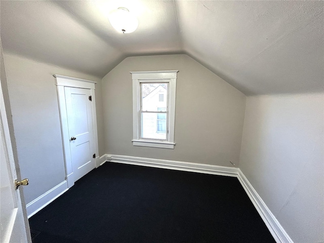 additional living space with lofted ceiling and baseboards