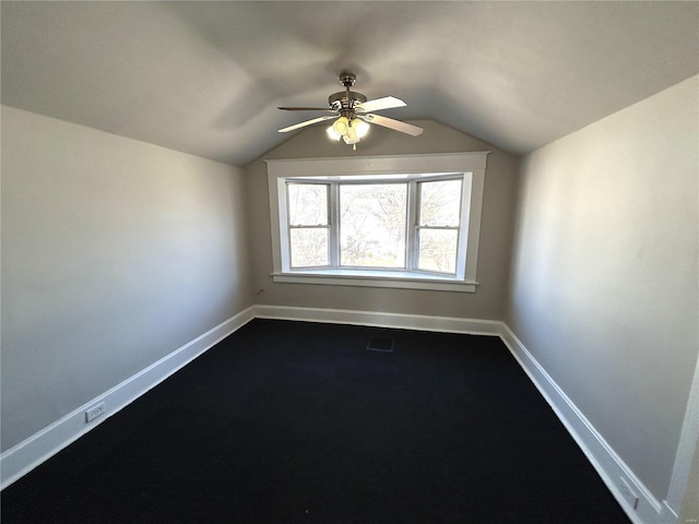 spare room featuring vaulted ceiling, a ceiling fan, visible vents, and baseboards