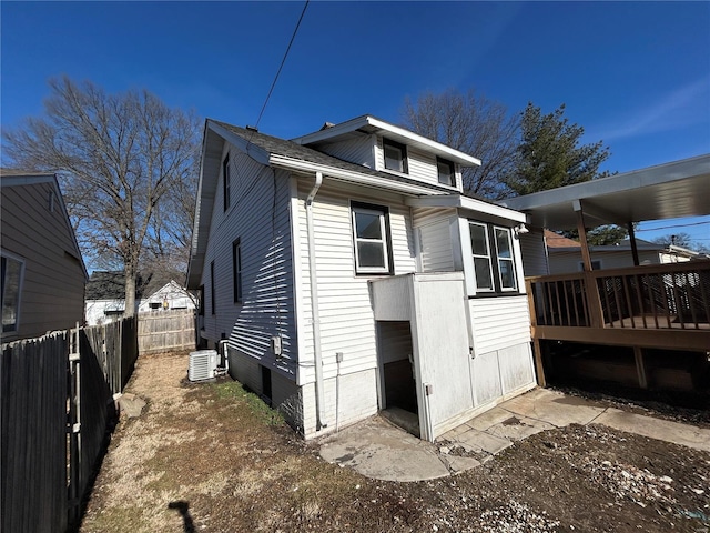 view of side of home featuring central AC unit and fence