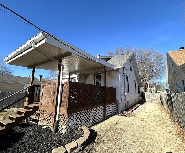 view of side of property featuring a fenced backyard and a wooden deck