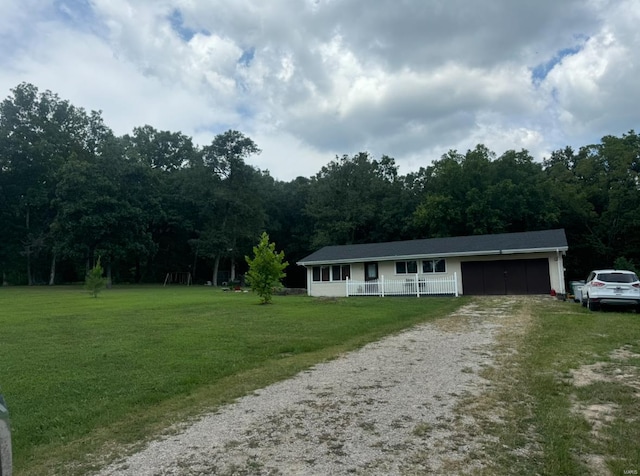 single story home featuring covered porch, driveway, a front lawn, and an attached garage