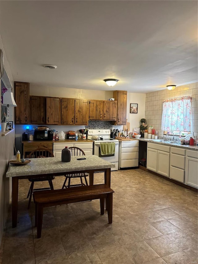 kitchen featuring visible vents, light countertops, backsplash, brown cabinets, and white electric range oven