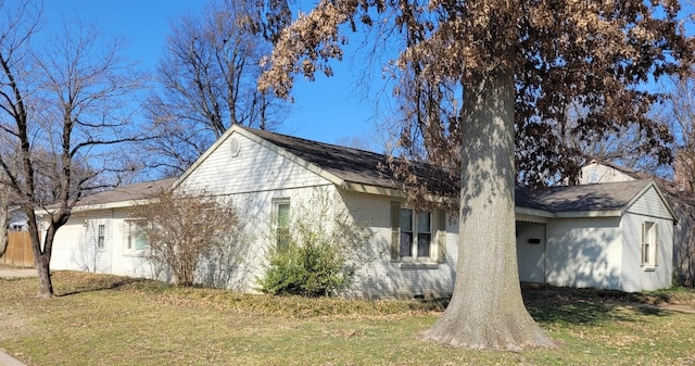 view of side of property featuring crawl space, brick siding, and a lawn