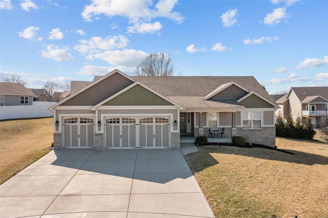 view of front of property featuring an attached garage, a porch, a front lawn, and concrete driveway