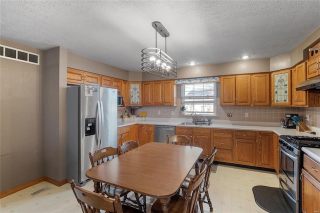 kitchen with light floors, appliances with stainless steel finishes, a sink, and visible vents