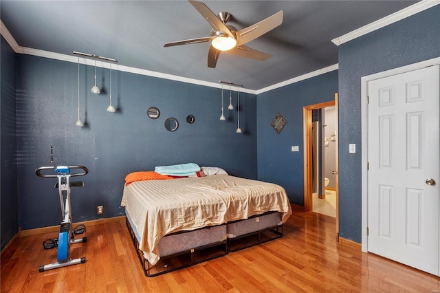 bedroom with a ceiling fan, baseboards, ornamental molding, and wood finished floors