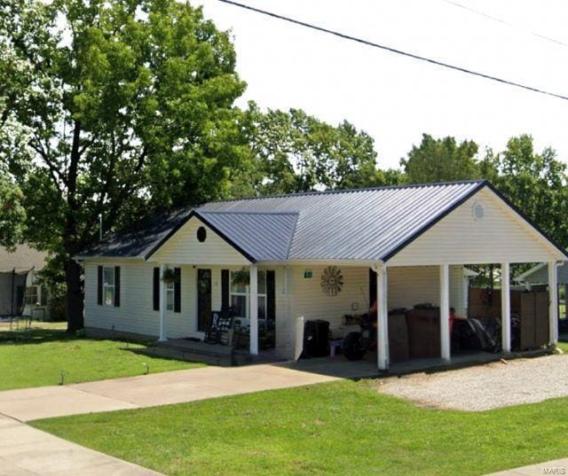 view of front facade with metal roof and a front lawn