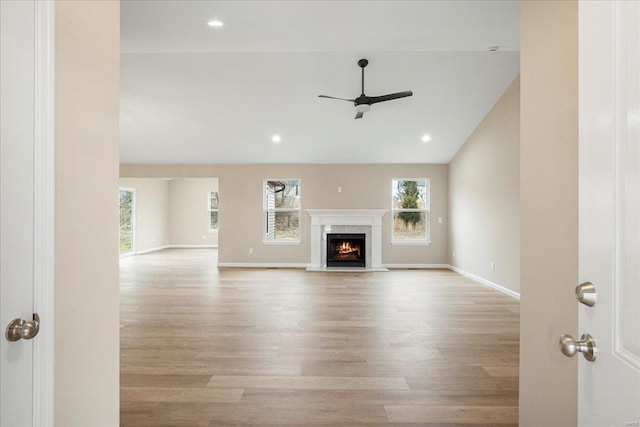 unfurnished living room featuring ceiling fan, recessed lighting, a fireplace, wood finished floors, and baseboards