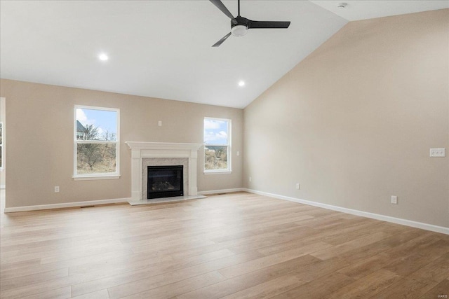 unfurnished living room featuring ceiling fan, light wood-type flooring, and plenty of natural light