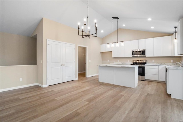kitchen featuring white cabinets, light wood-style flooring, stainless steel appliances, and a center island