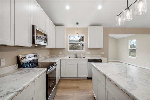 kitchen with plenty of natural light, white cabinetry, stainless steel appliances, and a sink