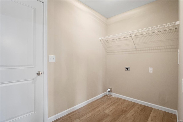 laundry room featuring light wood-type flooring, laundry area, hookup for an electric dryer, and baseboards