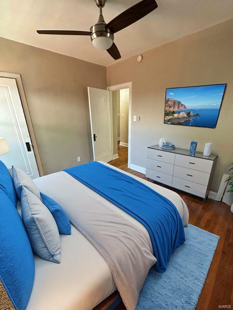 bedroom featuring ceiling fan, baseboards, and wood finished floors