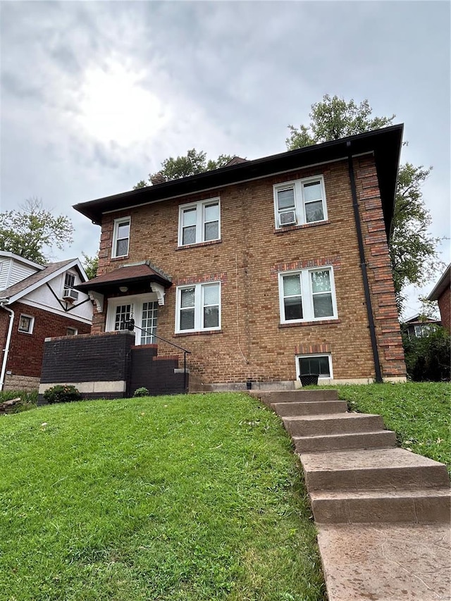 view of front of home featuring brick siding and a front yard