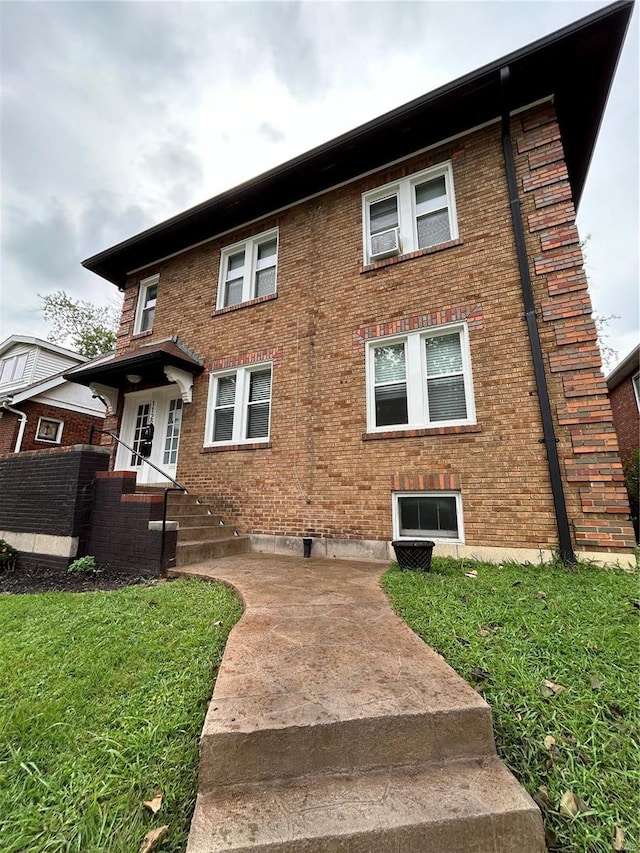 view of front of home with brick siding and a front yard