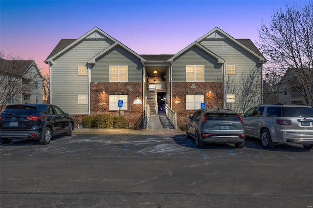 view of front of property with uncovered parking and brick siding