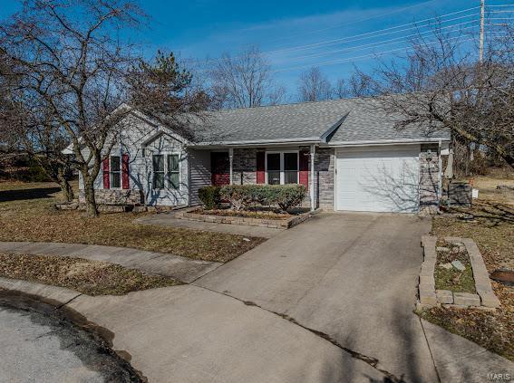 ranch-style home with a garage, concrete driveway, roof with shingles, and brick siding